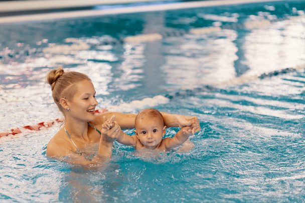 Moeder en zoontje hebben plezier in een zwembad - Foto, afbeelding