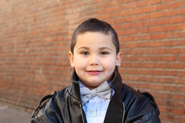 Na zewnątrz portret uroczy chłopiec słuch mucha i czarny skórzana kurtka - Zdjęcie, obraz