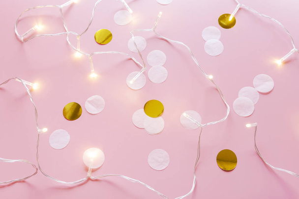 zábava strana pozadí: bílá a zlatá kruh konfety s LED světla na růžovém pozadí - Fotografie, Obrázek
