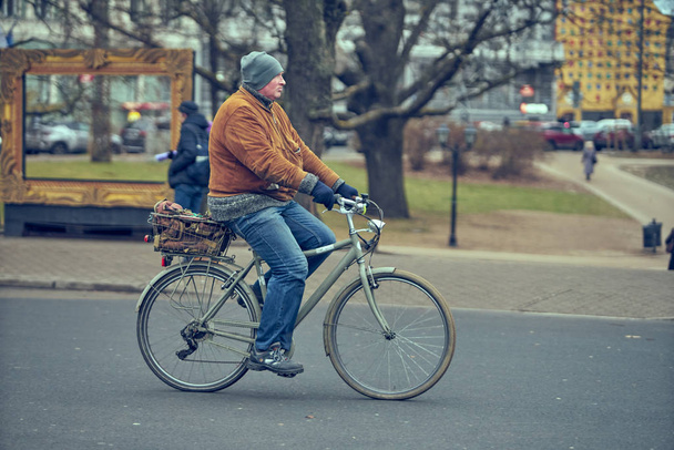 15-10-2019 Riga, Latvia. Handsome young man biking in the city streets - Foto, Imagen