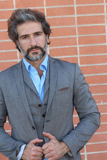 close-up retrato de belo empresário adulto em terno cinza na frente da parede de tijolo
 - Foto, Imagem