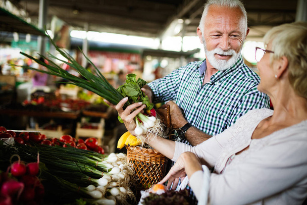 Senior couple shopping vegetables and fruits on the market. Healthy diet. - Foto, Imagem