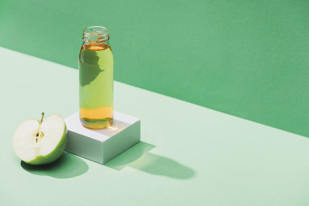 fresh juice near apple half and and white cube on green and turquoise background - Foto, Bild