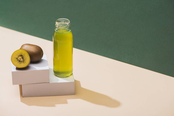 fresh juice near kiwi and and white cubes on green and white background - Photo, Image