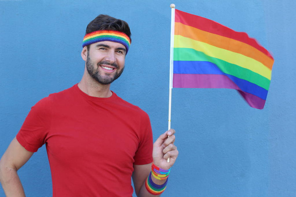 Handsome male proudly holding the LGBT flag - Photo, Image