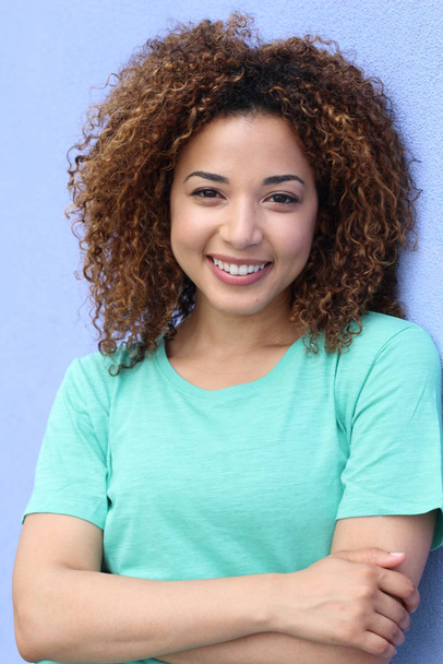 Latinská dívka s blond Afro účes usmívající se portrét na modrém pozadí s kopírovat prostor - Fotografie, Obrázek