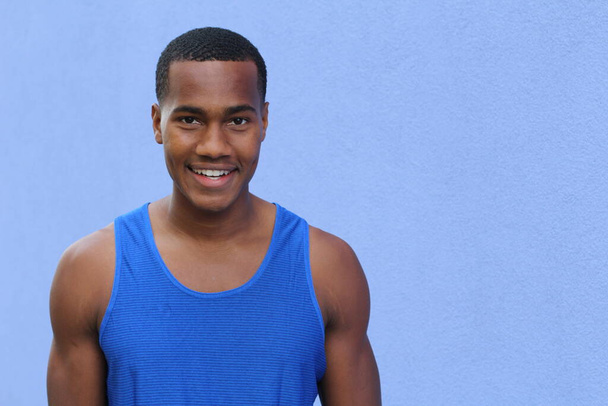 közeli kép jóképű afro-amerikai fiatalemberről a kék fal előtt - Fotó, kép