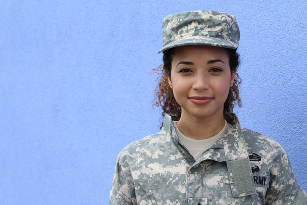 Military girl on blue background with copy space - 写真・画像