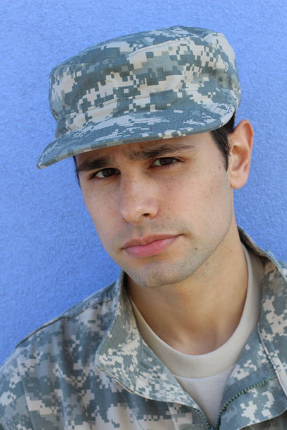 крупним планом портрет красивого молодого солдата перед синьою стіною
 - Фото, зображення