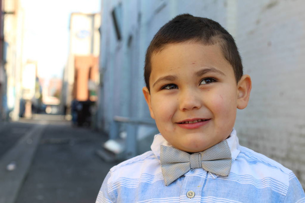 Szabadtéri portré aranyos kisfiú halló csokornyakkendő - Fotó, kép