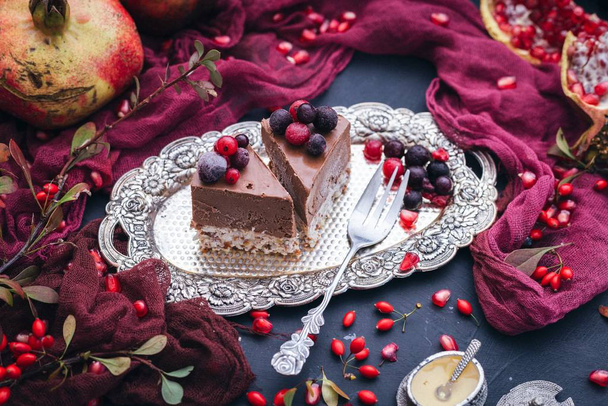 Two slices of vegan cake on a metal plate with berries on top - Foto, Imagem
