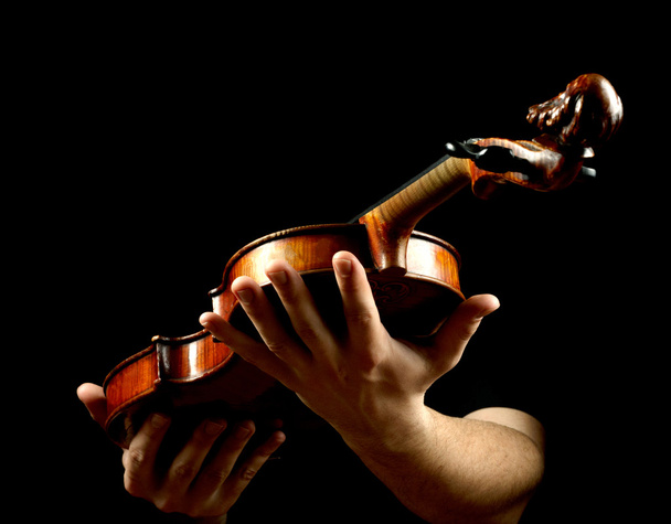 Hands holding violin isolated on black background - Foto, Imagem