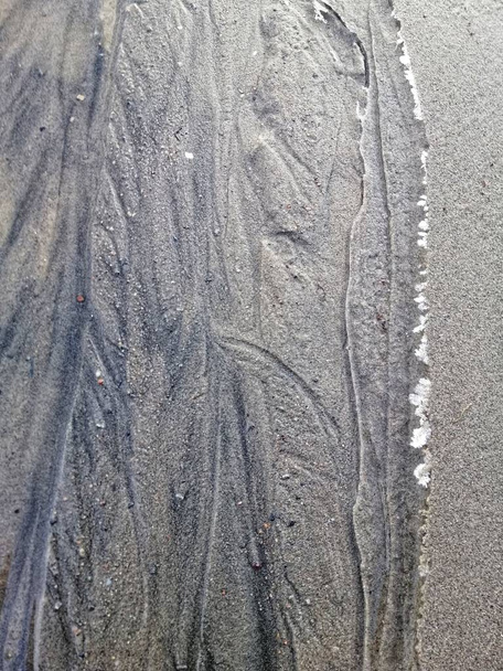 Een verticale close-up van het zand op het strand in Stavern Noorwegen - Foto, afbeelding