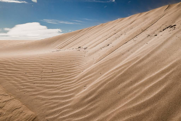 Sandy hills in a deserted area with traces left by the wind - Фото, изображение