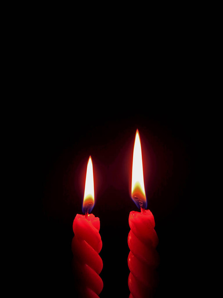 Κάθετη φωτογραφία ενός ζεύγους κόκκινου κεριού που καίγεται στο σκοτάδι, με ελεύθερο χώρο για κείμενο ή σχεδιασμό - Φωτογραφία, εικόνα