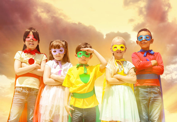 Милые маленькие дети, одетые как супергерои против облачного неба
 - Фото, изображение