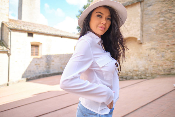 attractive woman tourist with hat in old italian town - Foto, Bild