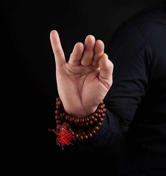 hand of an adult male shows mudra on a dark background - Foto, Imagem