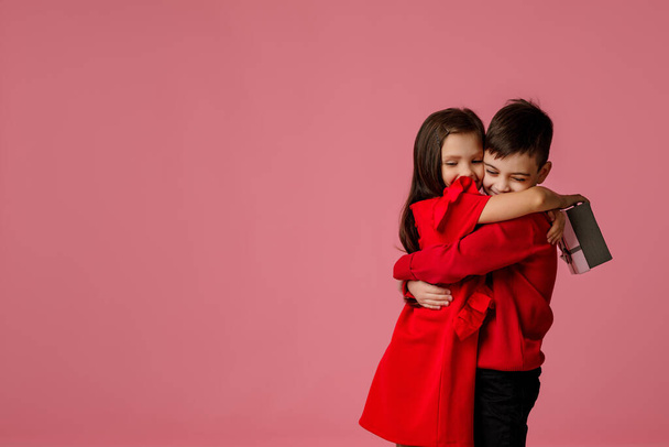 child girl and boy with gift box hugging - Fotó, kép