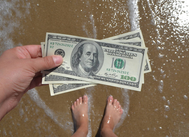 Chica sosteniendo la factura de dinero de 300 dólares en el fondo del mar océano - Foto, imagen