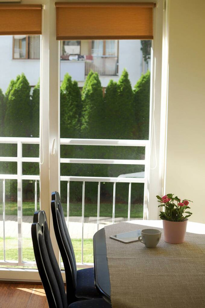 Πρωινό και ανάγνωση στην κουζίνα με πανοραμικά παράθυρα - Φωτογραφία, εικόνα