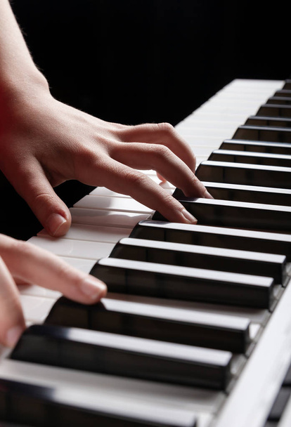 Closeup άποψη του παιδιού χέρια που παίζουν σε ηλεκτρονικά πλήκτρα πιάνο synthesizer. Κάθετη φωτογραφία έτοιμη για μουσικά καταστήματα, αφίσες, διαφημιστικά βιβλιαράκια, επαγγελματικές κάρτες, παρουσιάσεις στο διαδίκτυο. Θέση για κείμενο - Φωτογραφία, εικόνα