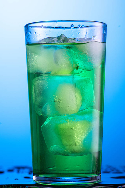 yellow or green carbonated lemonade in a glass with ice, flow and splash - Φωτογραφία, εικόνα