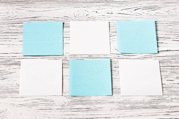 White and blue paper sheets on a wooden table. Abstract backgrou - Photo, Image