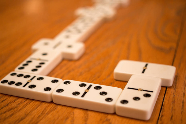 Playing the game of Dominoes on a wooded table  - Photo, Image