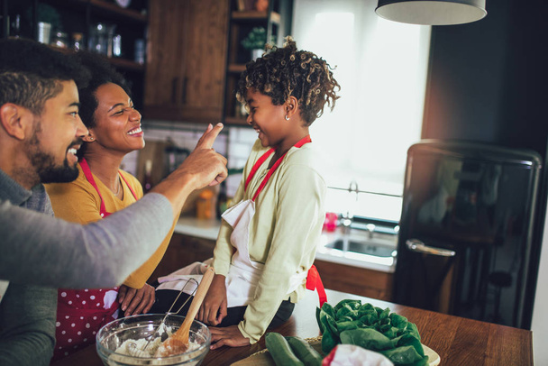 Szczęśliwy czarny rodzina spędzają dzień w kuchni. - Zdjęcie, obraz
