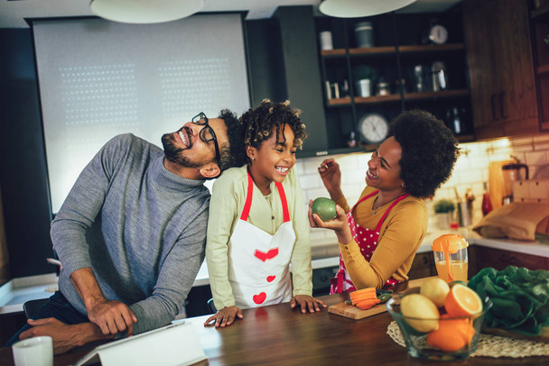 Gelukkig zwart gezin brengen dag in de keuken, met behulp van digitale tablet - Foto, afbeelding