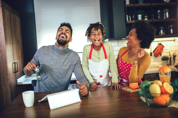 Feliz familia negra pasar el día en la cocina, utilizando la tableta digital
 - Foto, Imagen