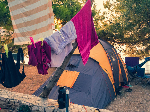Палатка для путешествий, одежда на бельевой веревке. Утро в лагере
.  - Фото, изображение
