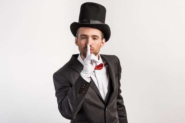 magician in gloves showing silence symbol, isolated on grey - Foto, afbeelding