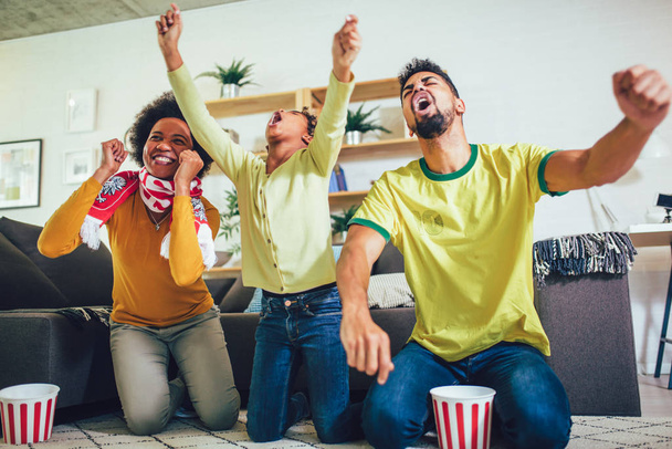 Boldog afro-amerikai család három tévénézés és ujjongott  - Fotó, kép