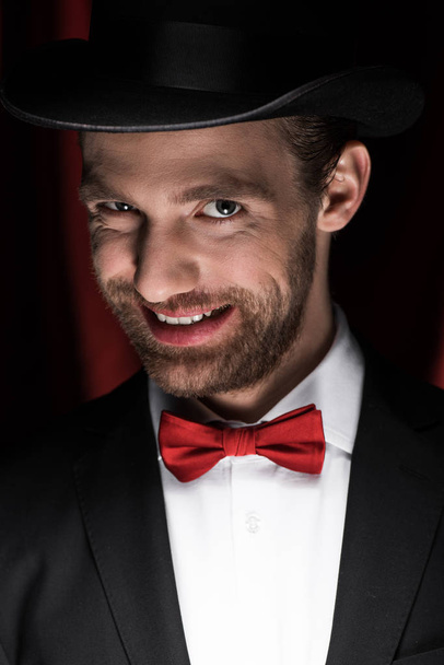 effrayant gentleman souriant en costume et chapeau dans le cirque avec des rideaux rouges
 - Photo, image