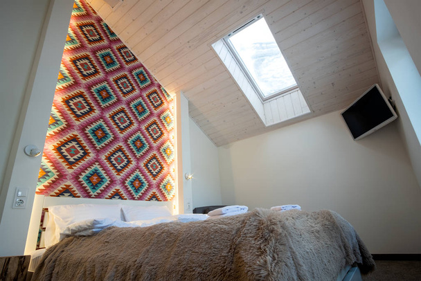 Interior of a spacious hotel bedroom on attic floor with fresh l - Foto, afbeelding