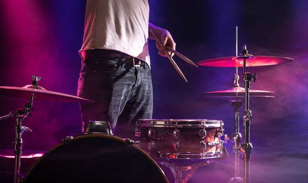 The drummer plays the drums. Beautiful blue and red background,  - 写真・画像