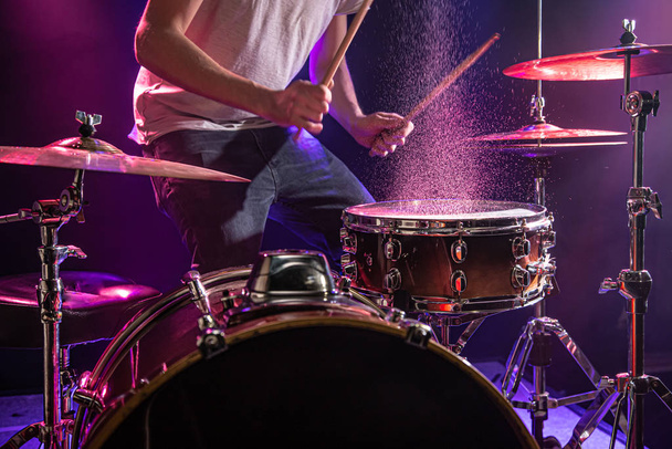 El baterista toca la batería. Hermoso fondo azul y rojo
,  - Foto, imagen