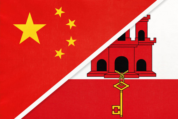 Chiny lub Prc vs gibraltarska flaga narodowa z tekstyliów. Stosunki między krajami azjatyckimi i europejskimi. - Zdjęcie, obraz