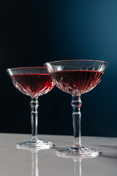 red wine in glasses on marble surface isolated on blue  - Zdjęcie, obraz