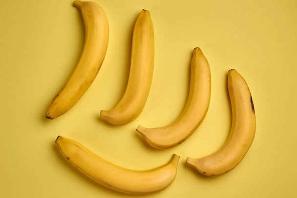 Ripe bananas on yellow background - Foto, immagini