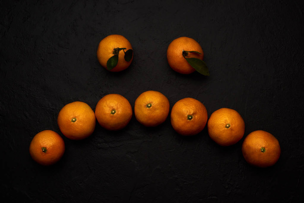 Ripe mandarins smiley on black background - Zdjęcie, obraz