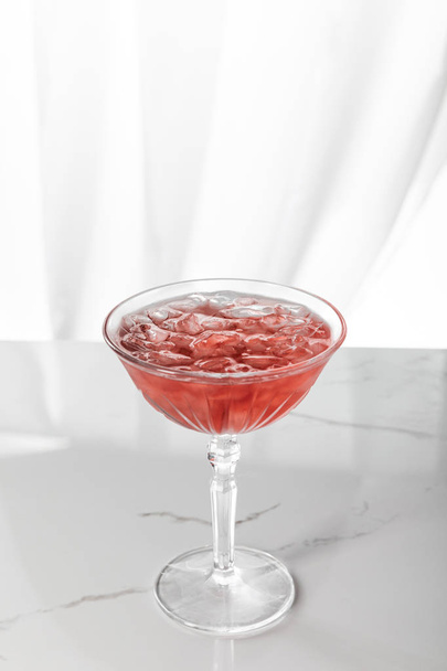 frozen ice cubes in glass with red cocktail on white  - Zdjęcie, obraz