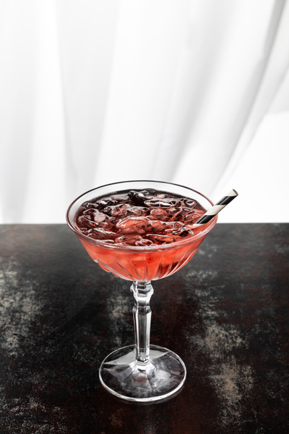 cosmopolitan cocktail with striped straw and ice cubes on white  - Foto, Imagem