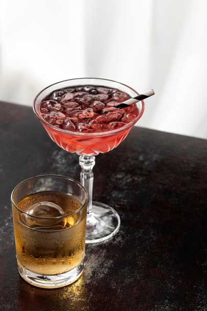 glas whisky bij kosmopolitische cocktail op wit  - Foto, afbeelding