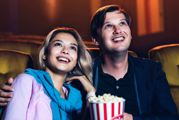 Caucasian lover enjoying to watch movie and eating popcorn together in the cinema - 写真・画像