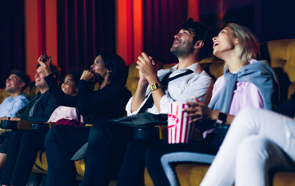 Ryhmä yleisö onnellinen ja hauska katsella elokuva elokuvateatterissa. Konsernin virkistystoiminnan ja viihteen käsite. - Valokuva, kuva
