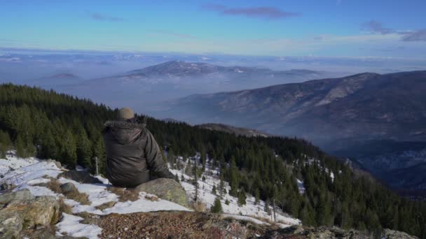 Az ember a téli tájat figyeli a hegyen. - Felvétel, videó