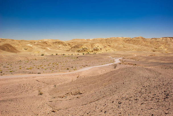 Wüste Landschaft Sand Stein Boden trocken Ödnis malerische Aussicht felsigen Hügeln Horizont Hintergrund Mittlerer Osten Israel warme Region - Foto, Bild